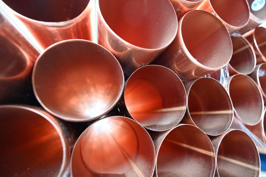 Kupferrohre liegen gestapelt und bereit für den Einsatz im Bauwesen im Baumarkt, ideal für Rohbauprojekte.